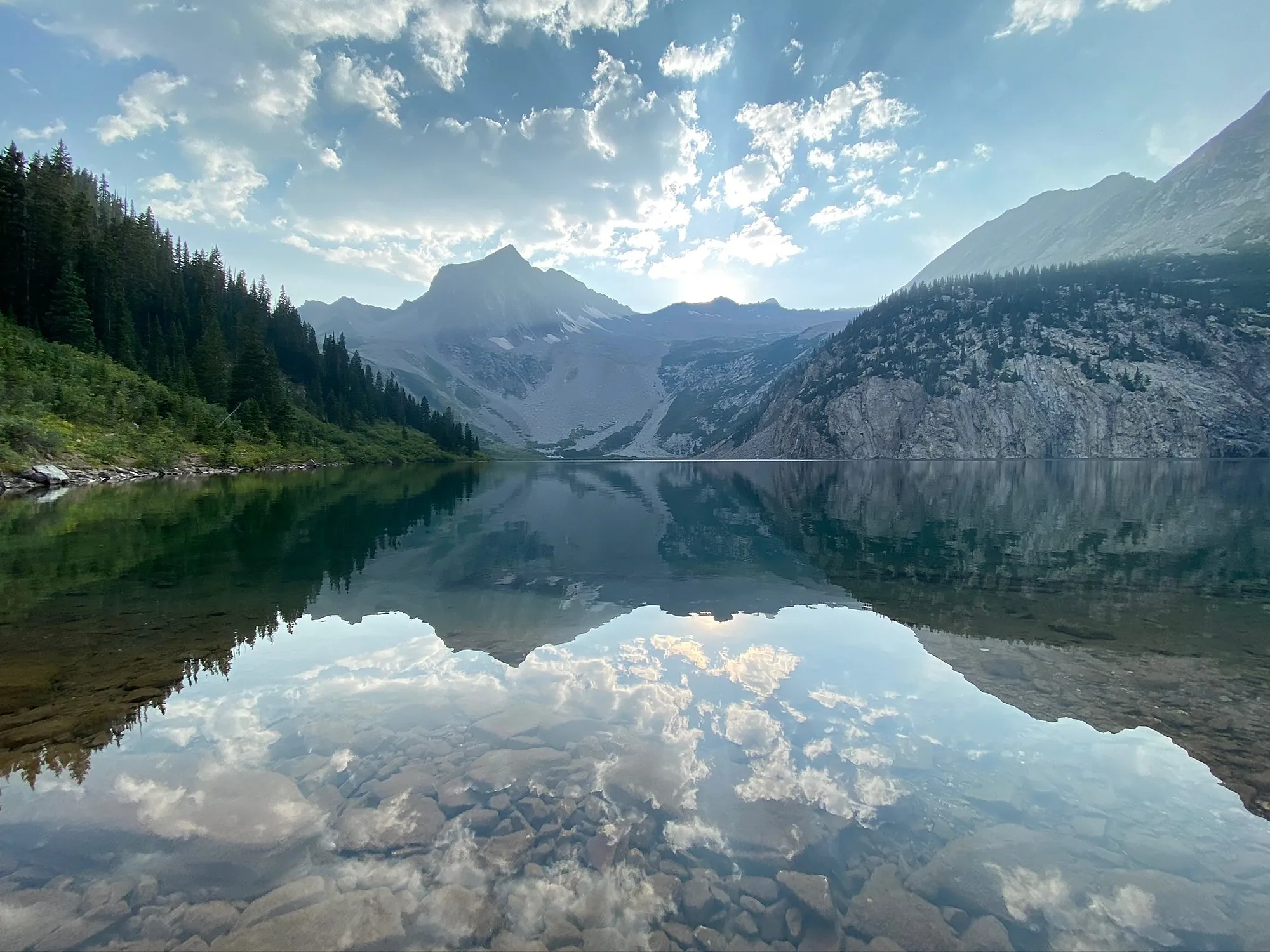 A mountain lake holding a mirrored reflection of the ridge above it